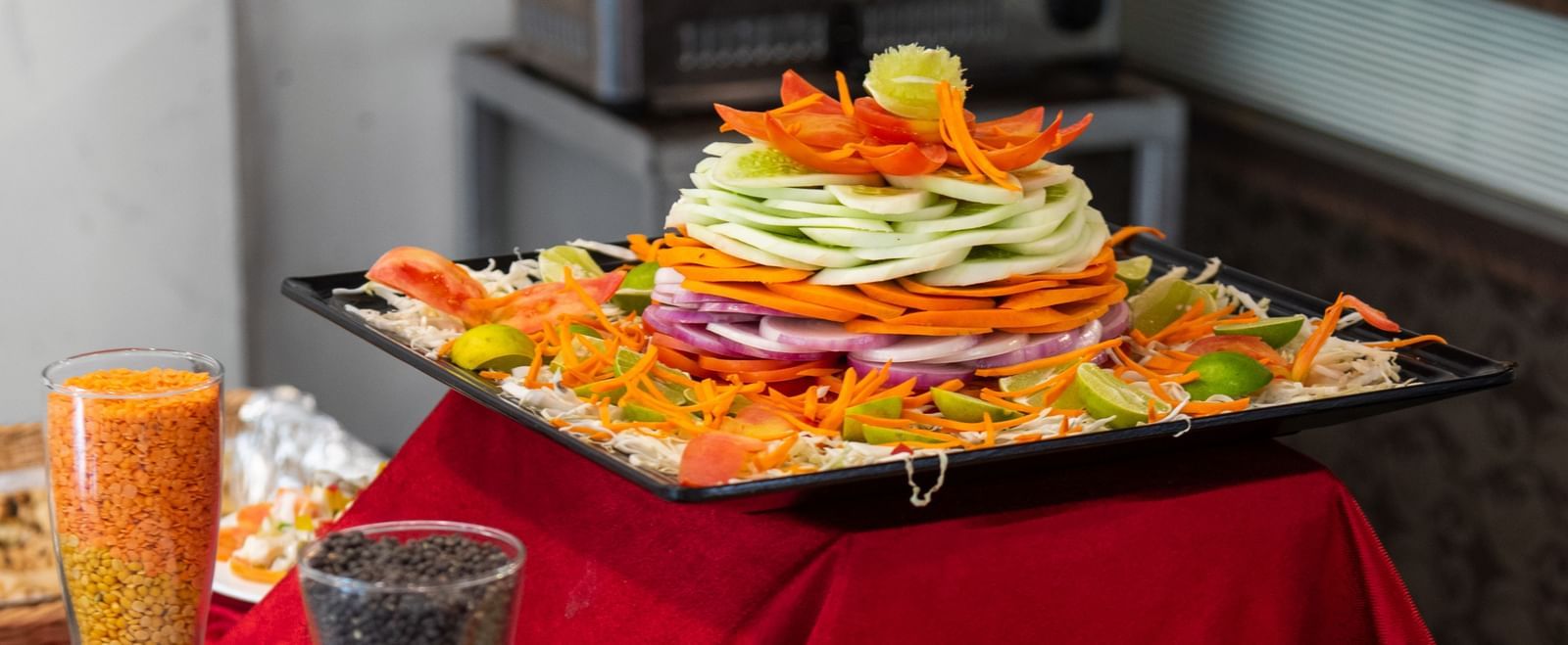 A dish displayed on a table with red cloth at The Darbar Restaurant with side dishes.