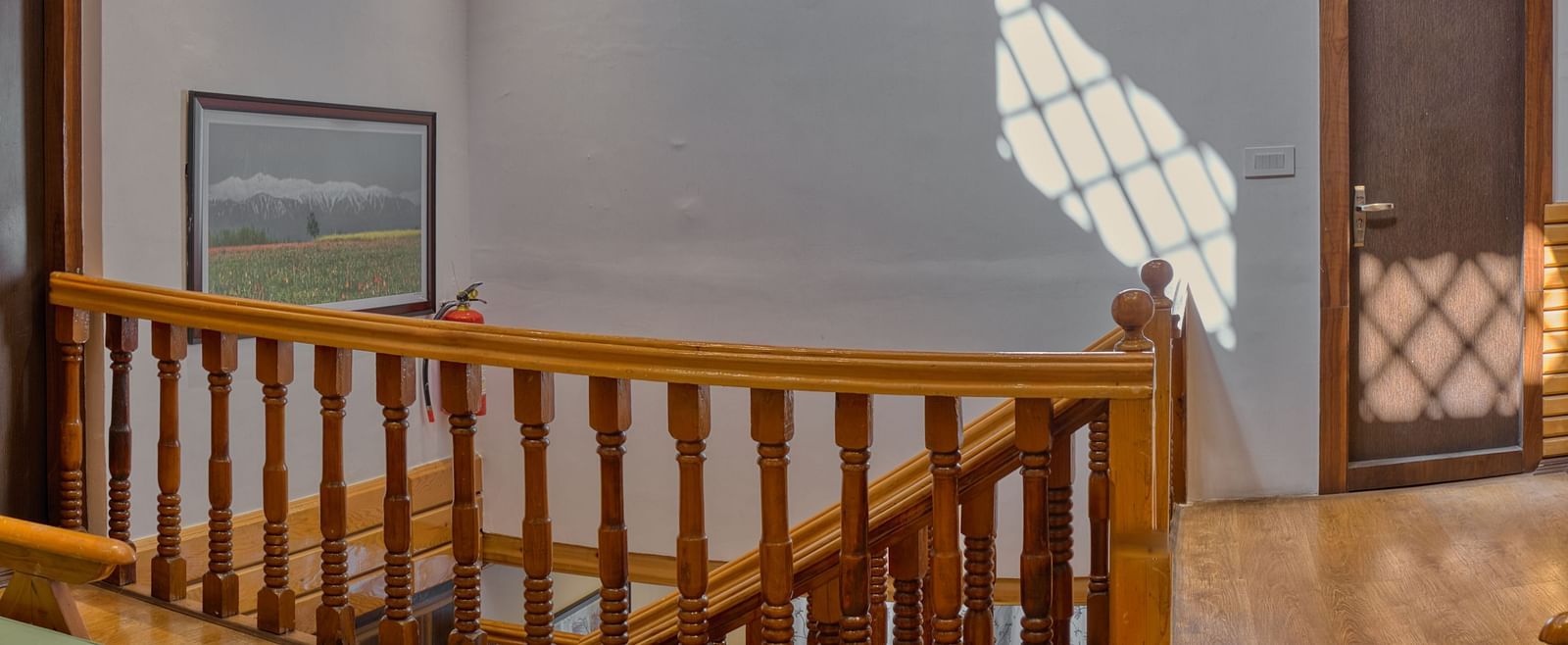 Intricate ceiling design above a grand staircase at Royal Comfort Regency, adding elegance to every arrival and departure.