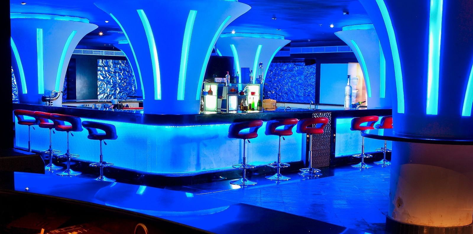 Ska bar Discotheque with neon lights featuring a bar counter and several chairs around it at Ocean Spray Puducherry