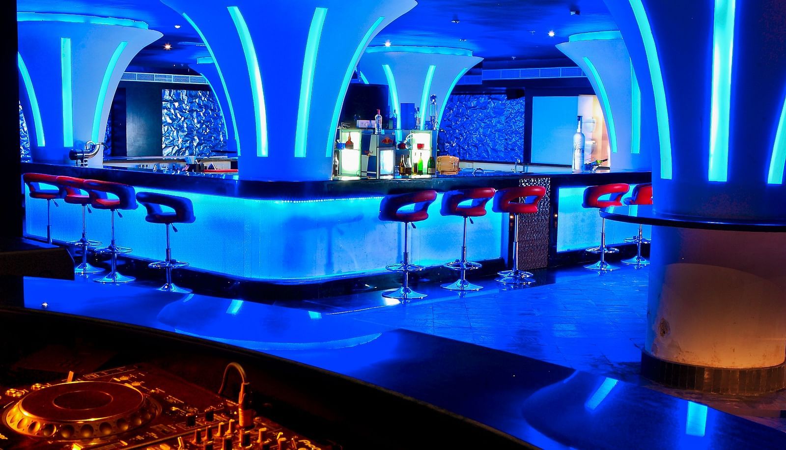 Ska bar Discotheque with neon lights featuring a bar counter and several chairs around it at Ocean Spray Puducherry