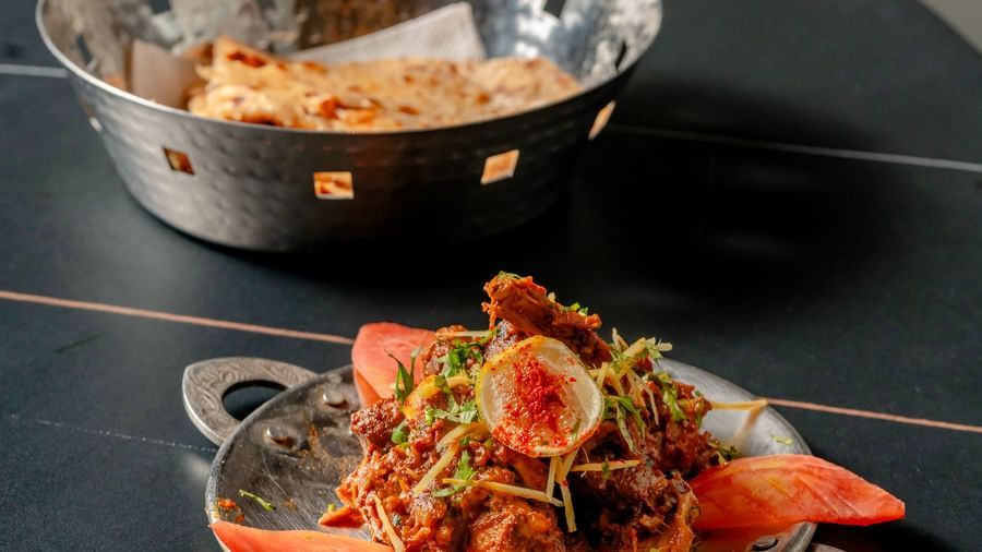 Delicious Indian curry or gravy served in a small metal bowl on a table | Pravasa Hotel, Vijayapura