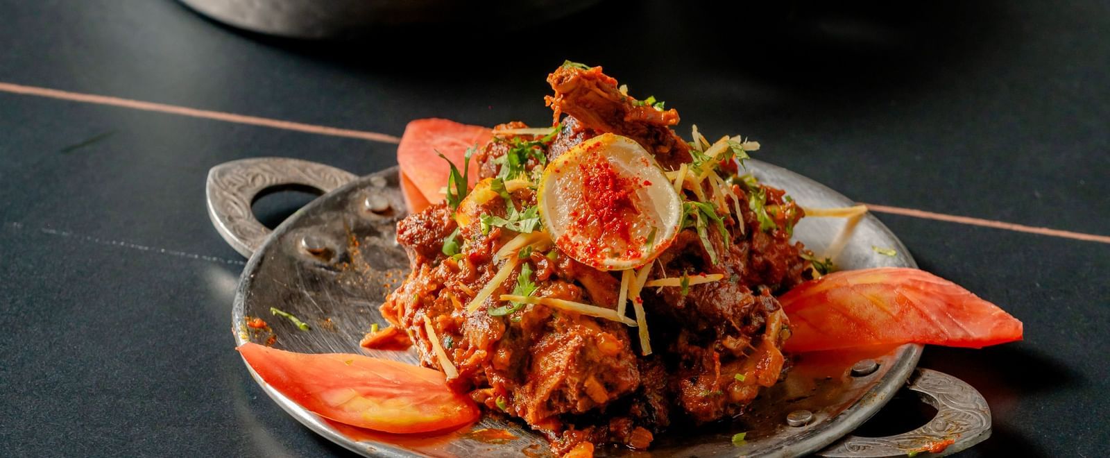 Delicious Indian curry or gravy served in a small metal bowl on a table | Pravasa Hotel, Vijayapura