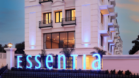 Facade of Essentia Premier Hotel, Chennai in the early evening with the lights on on each floor