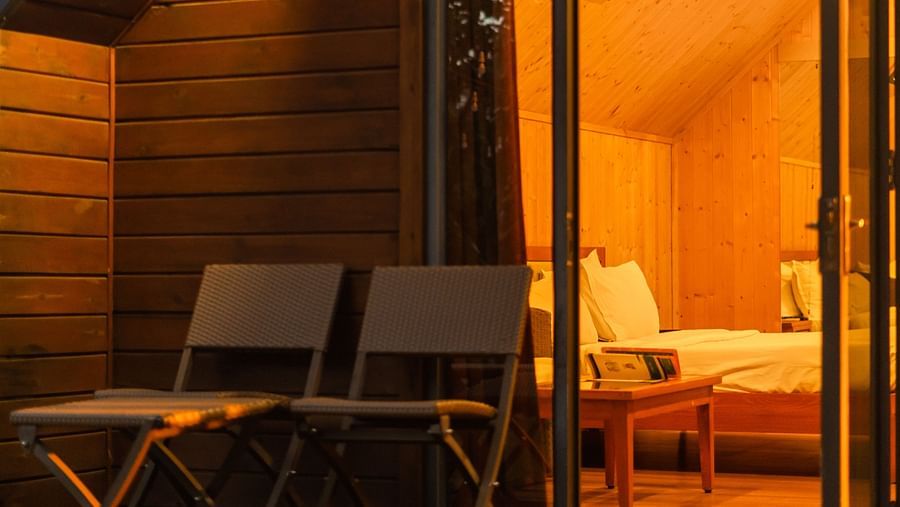 Evening view of the Cottage Room at Crescent Spa & Resort, Indore, featuring warm lighting that creates a decorative and inviting ambiance