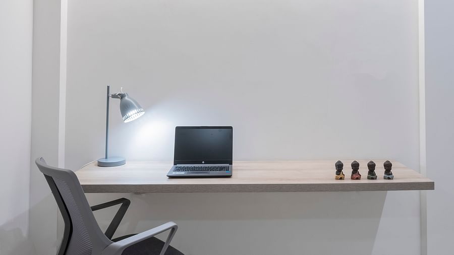 Corner workspace with table, lamp and desk setup at Nest by Rivido Apart Hotel, Bannerghatta Road