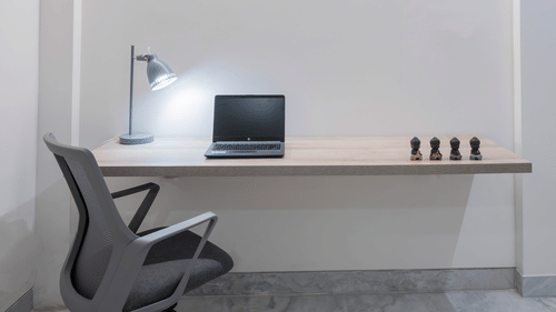 Corner workspace with table, lamp and desk setup at Nest by Rivido Apart Hotel, Bannerghatta Road