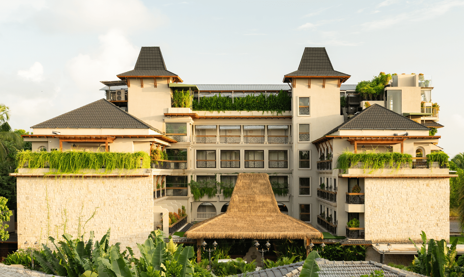 The exterior of The Evren, Vagator illuminated with sun rays with a bright blue sky in the background.