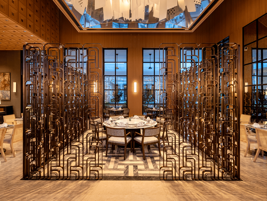 Front view of Chin Chin restaurant at The Residency Signature Madurai with decorative metal partitions, pendant lighting, and warm ambient lighting.