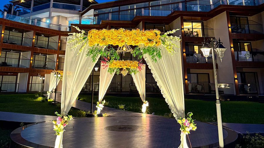An outdoor event setup with floral arches and the hotel building in the background, located at Silver Sand Sea Princess Beach Resort, Port Blair.