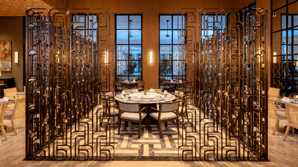 Front view of CHINCHIN restaurant at The Residency Signature Madurai with decorative metal partitions, pendant lighting, and warm ambient lighting.