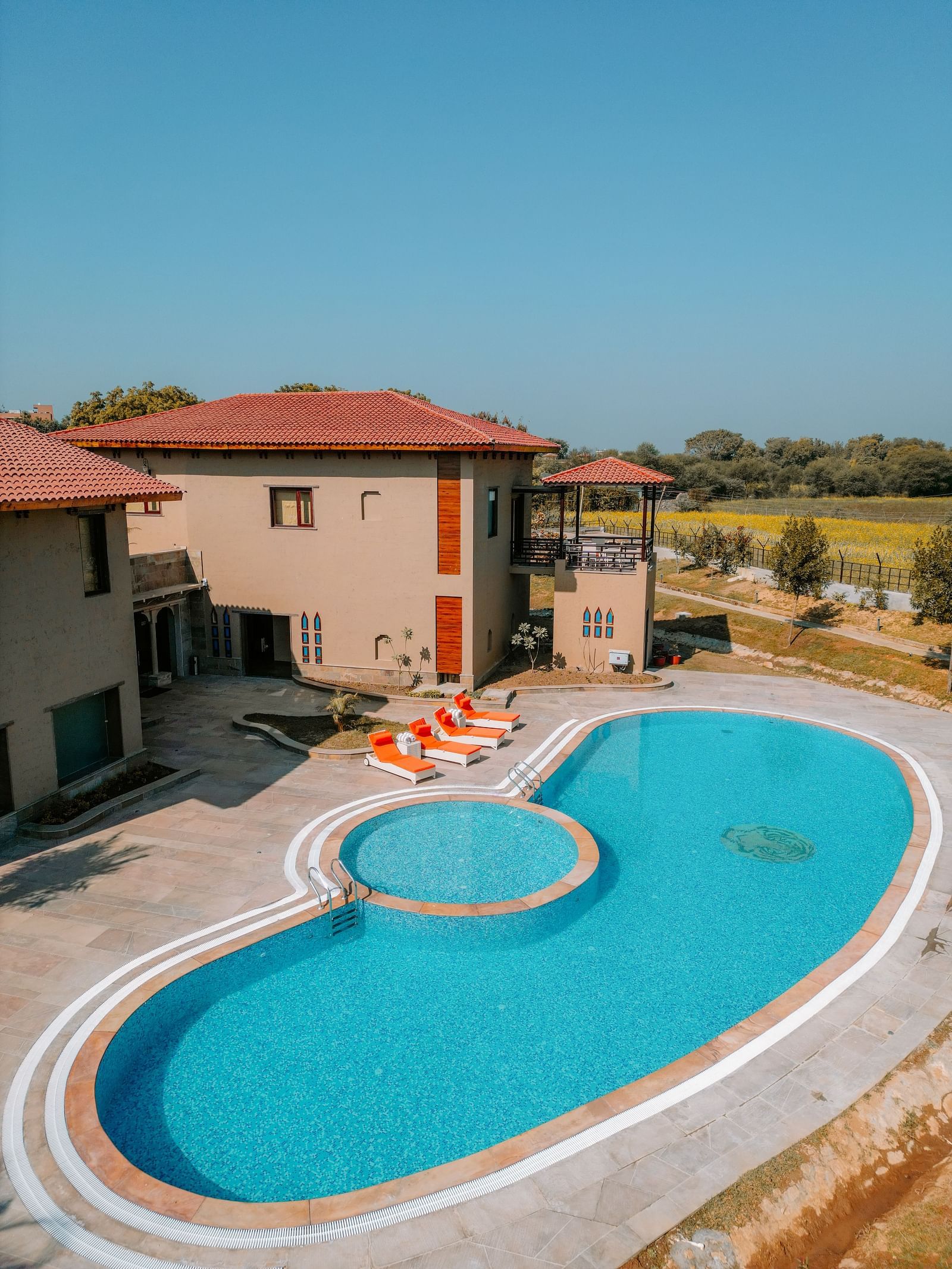An inviting swimming pool with a unique shape beside a resort building at Aamaghati Wildlife Resort.