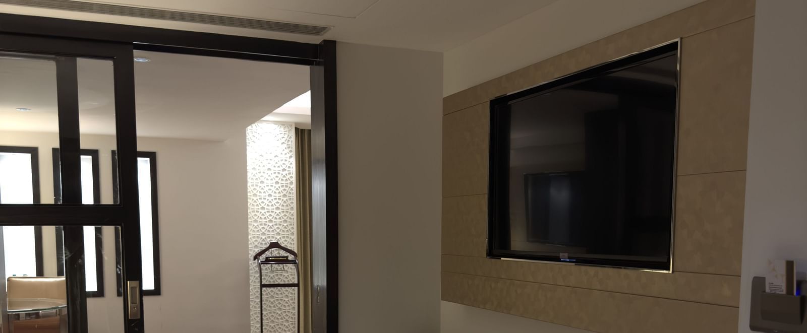 A room with a bed, a seating area, and a wall-mounted television at Cenneys Gateway.