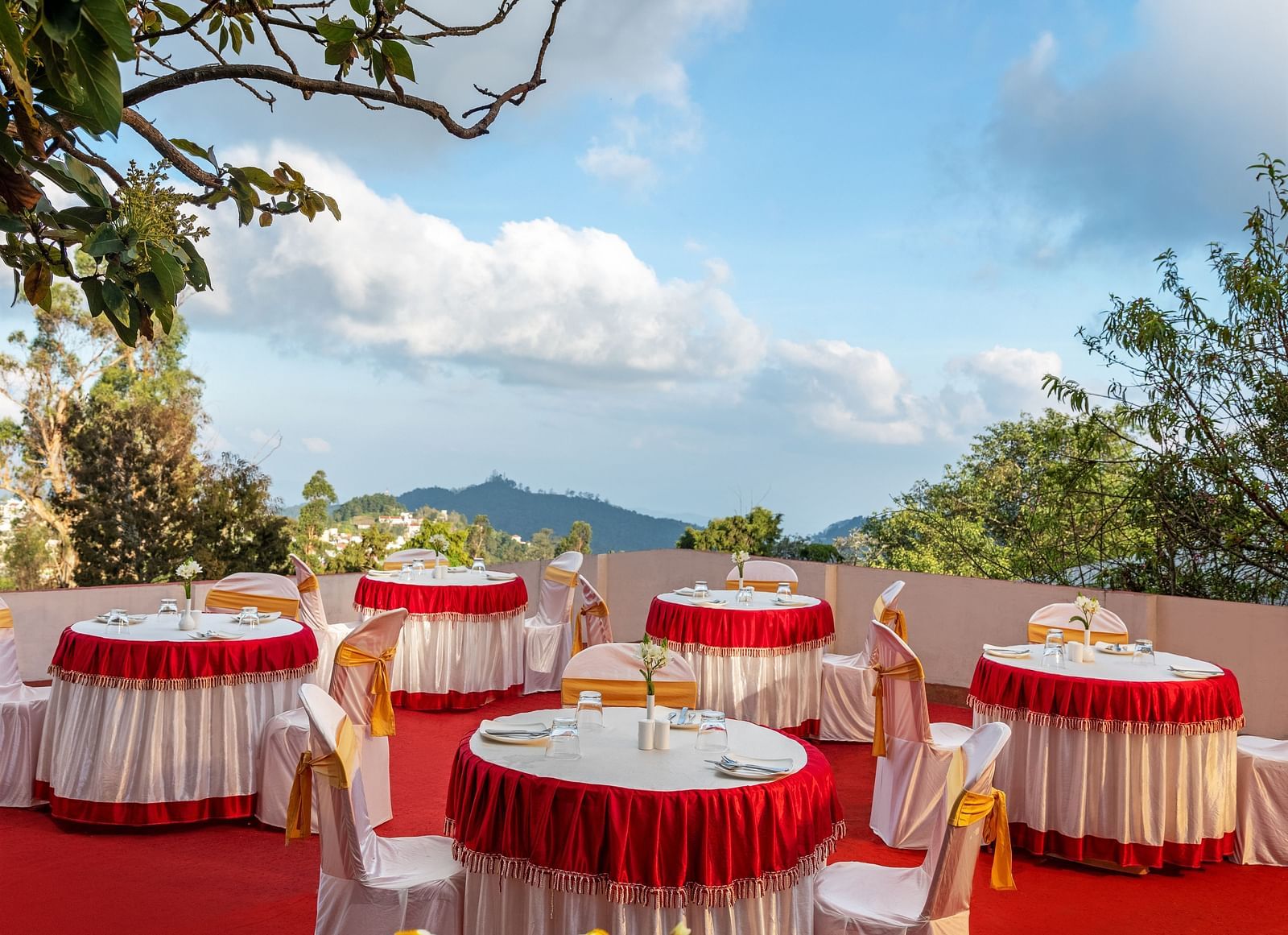 A picture where small round tables are placed with two chairs in each setting | Mango Hill, Kodaikanal