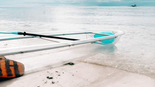 A glass-bottom boat ride, Havelock, on the beach with blue skies covered in white clouds in the background.