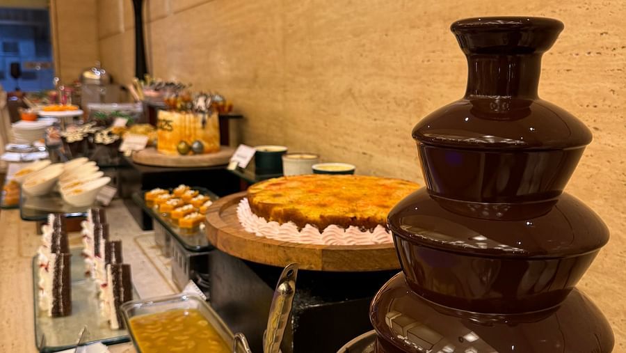 A chocolate fountain with various dipping items arranged on a buffet table at Cenneys Gateway.