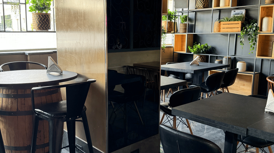 A modern dining area with dark furniture and subtle lighting at Cenneys Gateway - Pride of Salem..