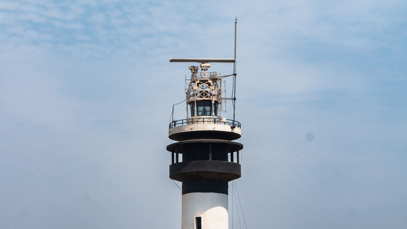 Black and white lighthouse standing tall against a clear blue sky.