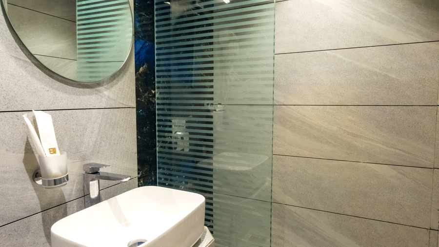 Stylish ensuite bathroom with glass shower enclosure at Home2 Residency, Mumbai Airport