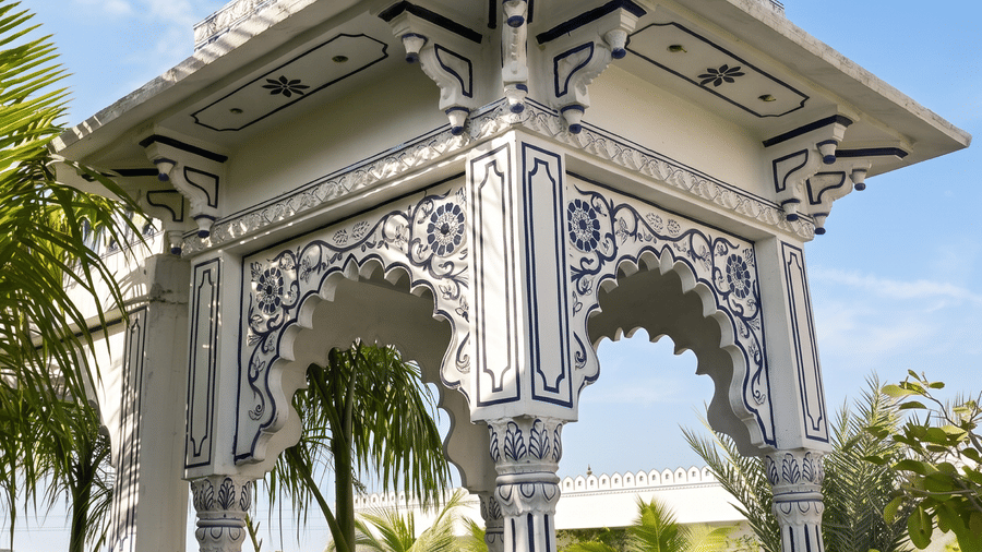 Close-up of an ornate stone dome gazebo surrounded by trees and bushes at Mukundra Sarovar Premiere hotel in Kota.
