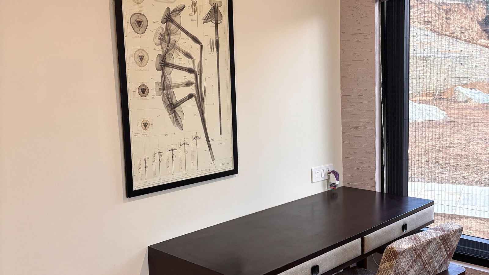 Study area with a desk, chair, and a wall-mounted photo frame above the desk at The Chamomile Estate.