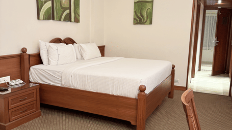 A side view of a large bed with photo frames above the headboard | Cenneys Gateway - Pride of Salem.