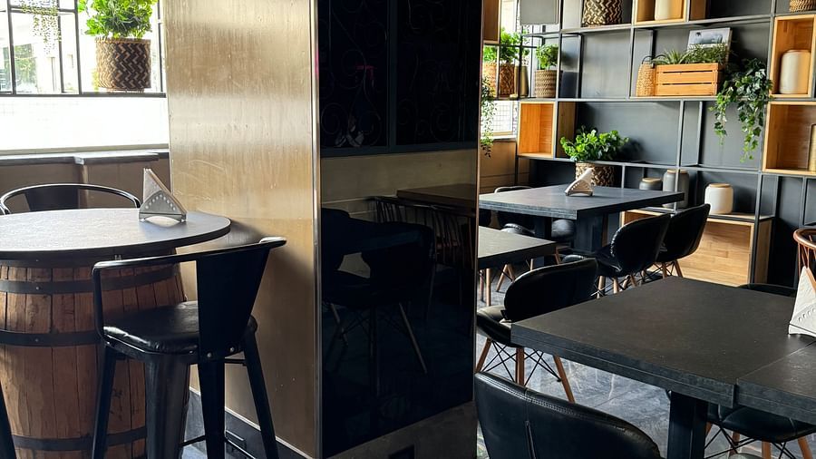 A modern dining area with dark furniture and subtle lighting at Cenneys Gateway.
