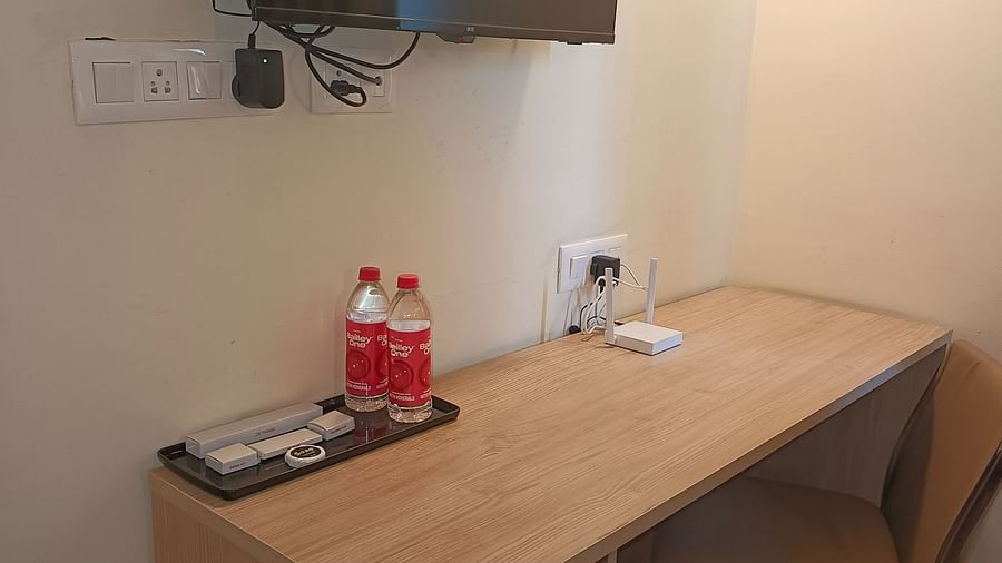 Work desk facing the wall and a TV mounted on the wall over it inside Premium Studio at Starlit Suites, Shirdi