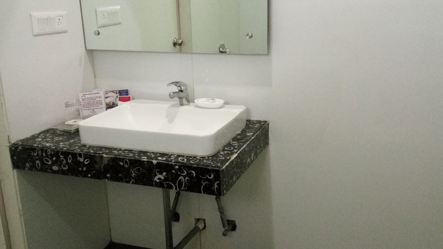 a bathroom at Top3 Lords Resort Bhavnagar with a single faucet, a mirror, and a partial view of the water closet
