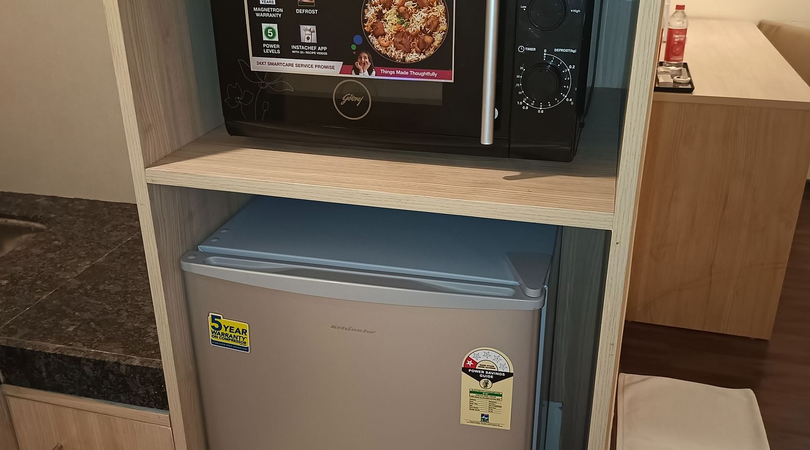 Microwave oven and fridge in the kitchenette inside Premium Studio at Starlit Suites, Shirdi