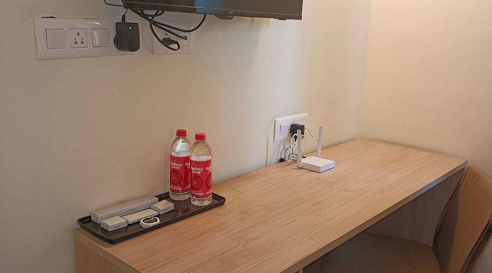Work desk facing the wall and a TV mounted on the wall over it inside Premium Studio at Starlit Suites, Shirdi