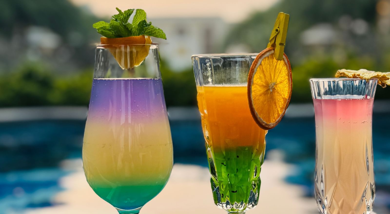 A stunning sunset view by the pool with elegant cocktail glasses - Kaldan Samudra Palace