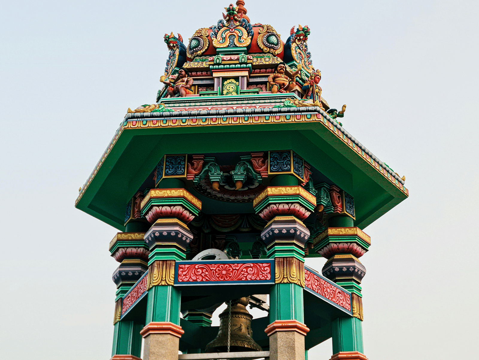 Colourful pillared tower of a South Indian temple against a clear sky.