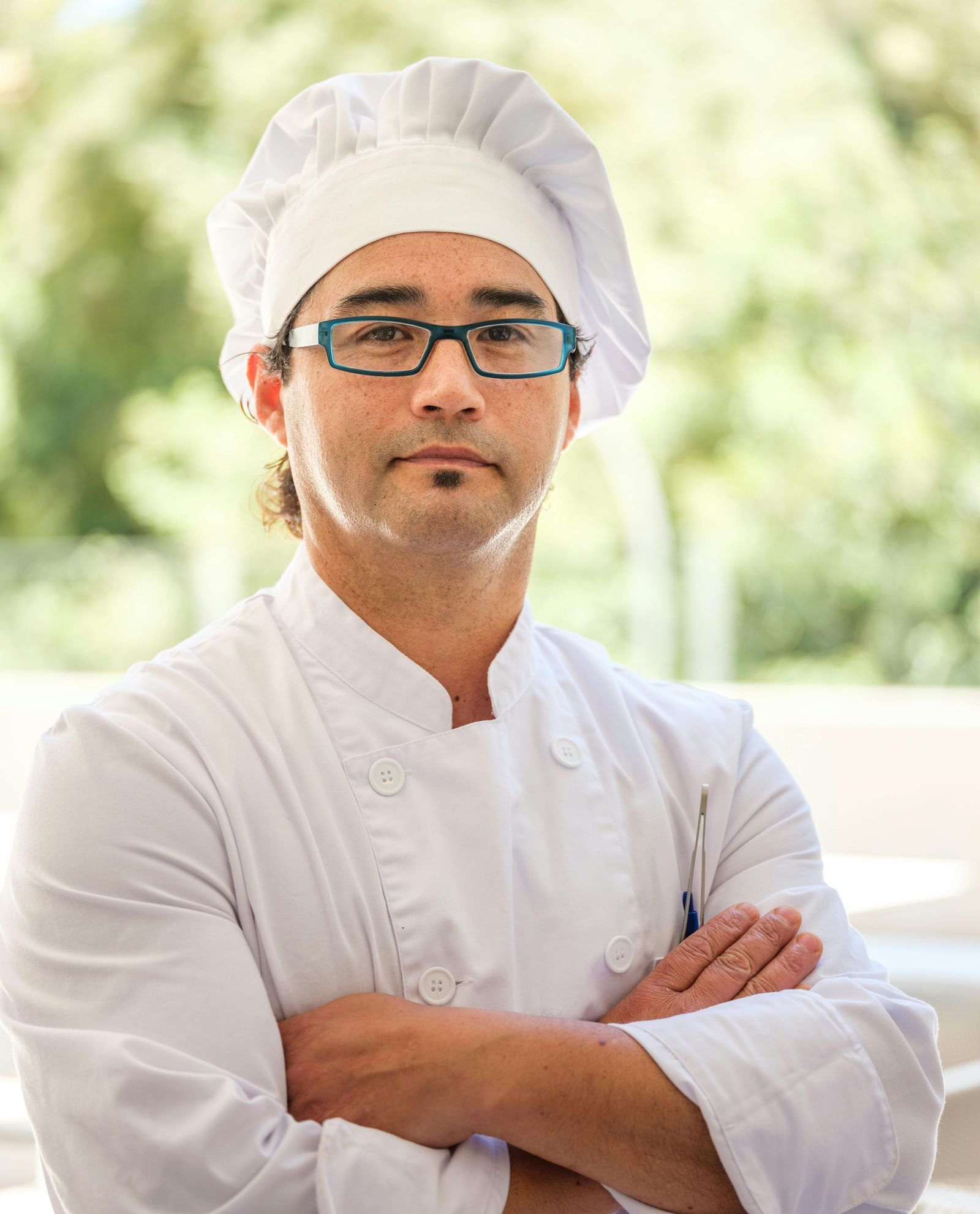 A chef dressed in white posing for the camera