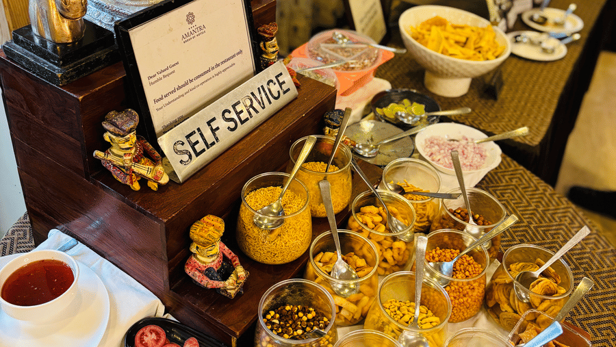 A close-up shot of the lavish buffet counter with an assortment of several dry snacks at the Navidya Restaurant - Amantra Comfort Hotel