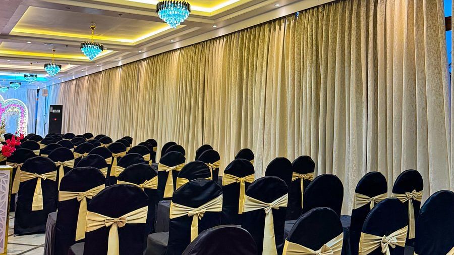 At Silver Sand Sea Princess Beach Resort, Port Blair, rows of chairs with black covers and gold sashes in an  hall.