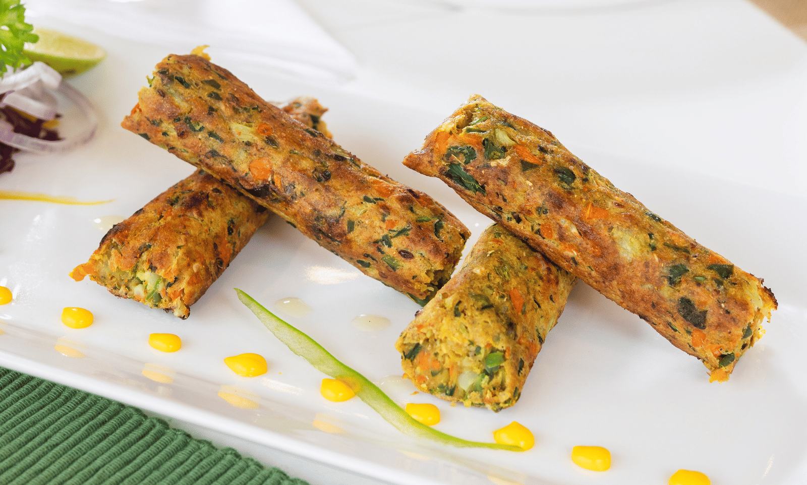 A white rectangular dish holds several fried spring rolls drizzled with a sauce - Megha Resort & Villas, Dehradun