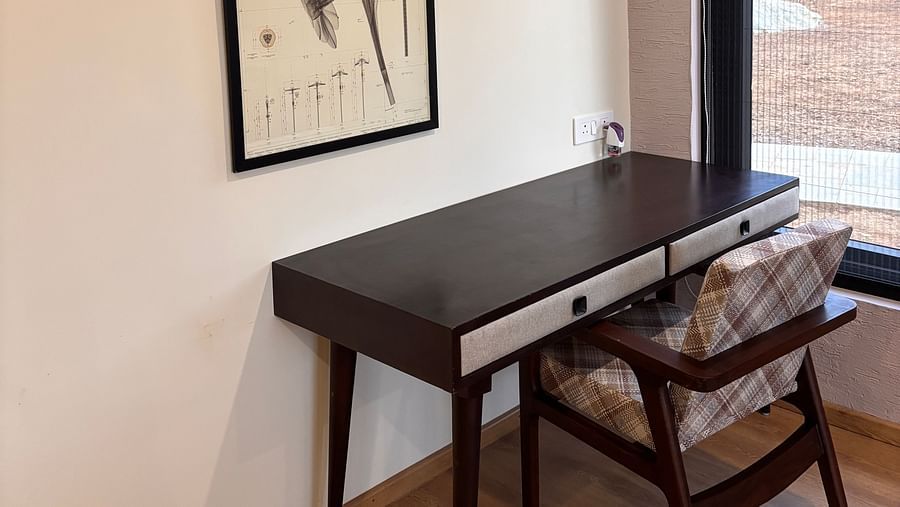 Study area with a desk, chair, and a wall-mounted photo frame above the desk at The Chamomile Estate.