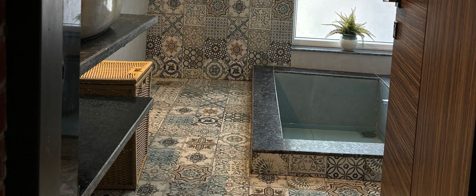 Modern bathroom with patterned tiles and enclosed shower area at Tisya Farms, Gurgaon.