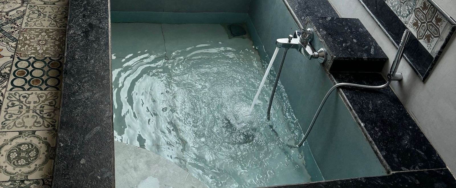 Indoor jacuzzi setup in a tiled bathroom at Tisya Farms, Gurgaon.