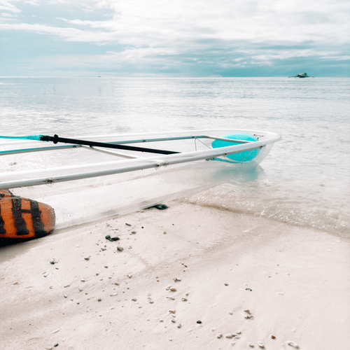 A glass-bottom boat ride, Havelock, on the beach with blue skies covered in white clouds in the background.