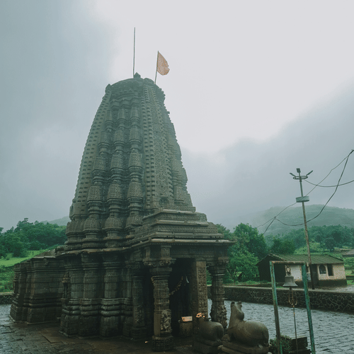 Intricately carved stone temple (Mandir) under a clear sky.