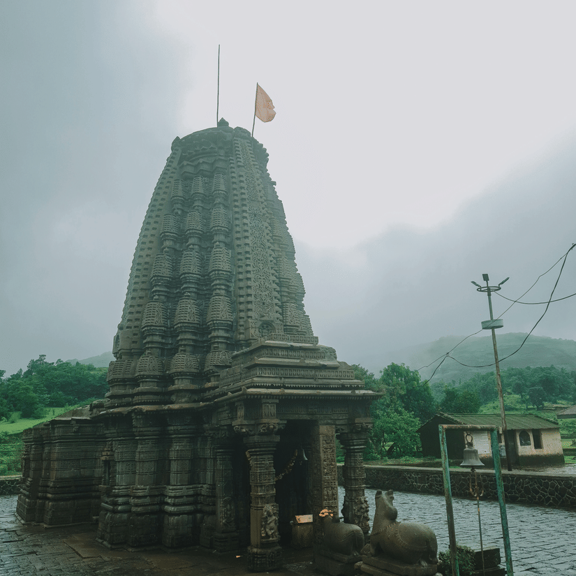 Intricately carved stone temple (Mandir) under a clear sky.