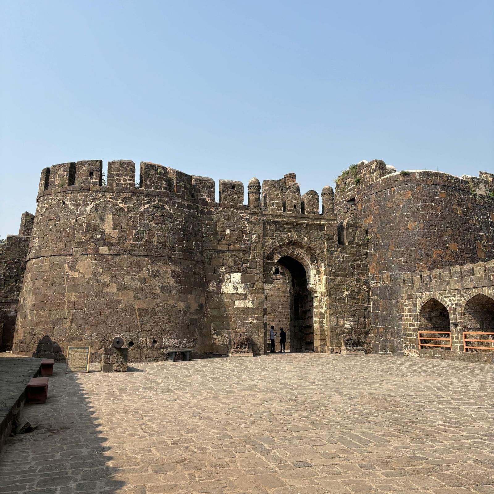 Old stone fort with high walls and arched gateways standing strong against the sky.