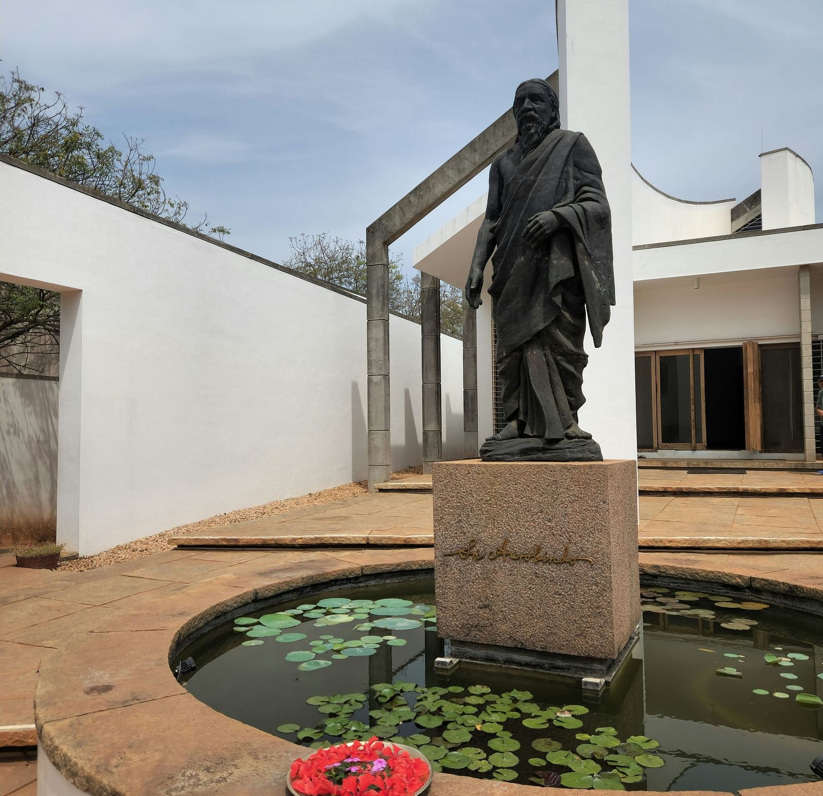 A statue of aurobindo in auroville inside a tank of water