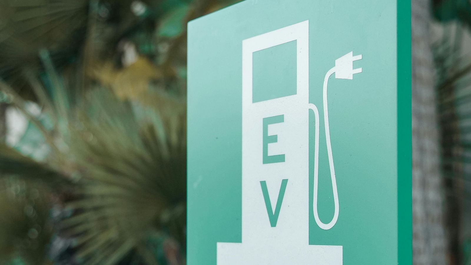 A poster featuring an icon with EV written on it, indicating EV charging.