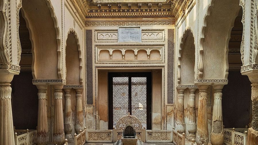 An ornate interior view of a heritage site with detailed arches and a central structure.