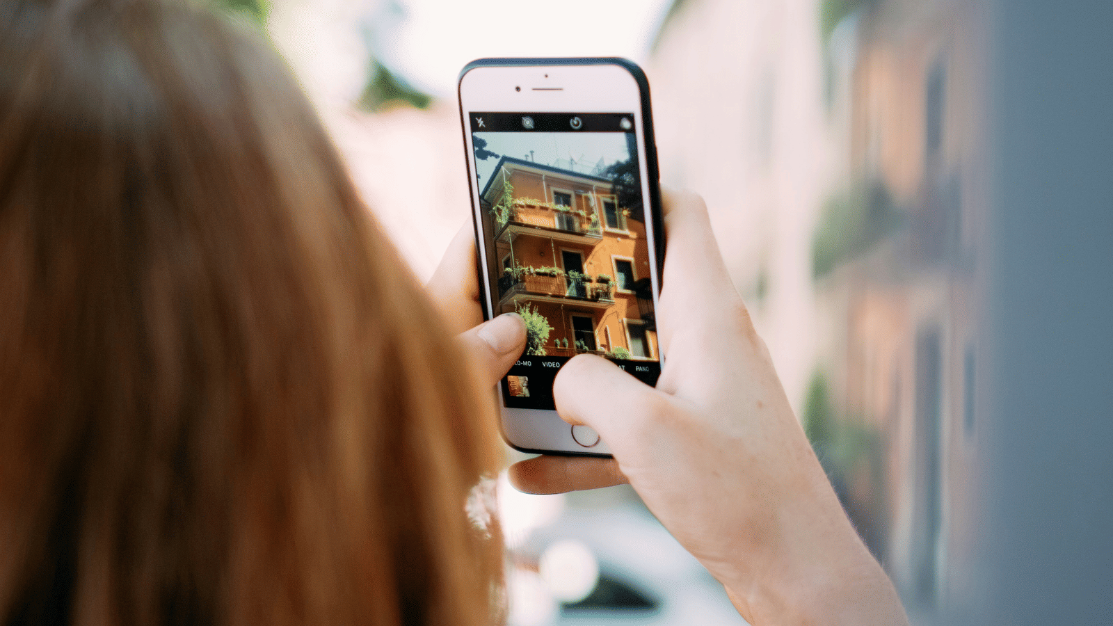 A woman taking a picture on her cellphone with a tree on the side during a Photoshoot in Pune.