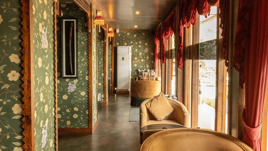 An outdoor dining space with sofas, chandeliers and decorated walls. | The Heritage Club, Tripura, Castle, Shillong