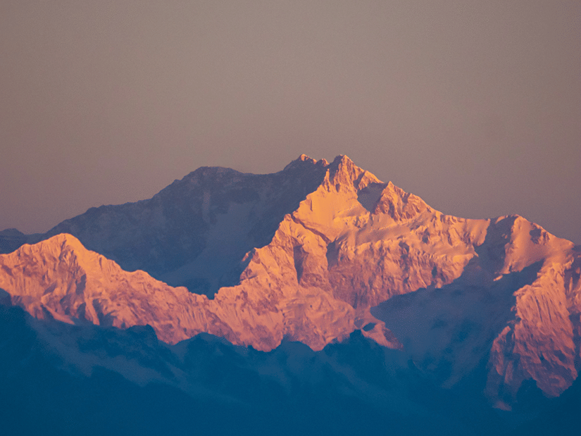 Sunrise over the snow-covered peaks of Mount Kanchenjunga, showcasing the breathtaking Himalayan landscape.