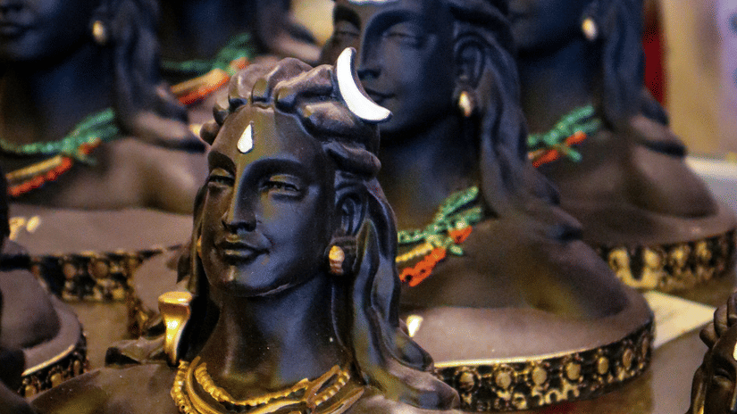A close up of many busts of Shiva places next to each other in display to be sold.